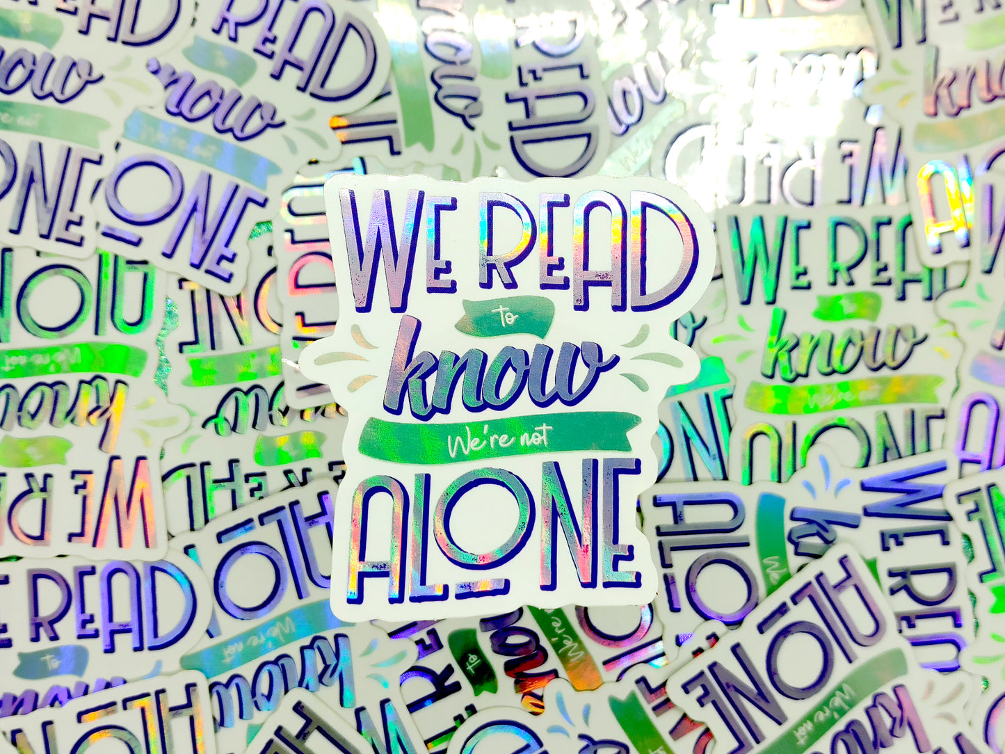 We read to know we're not alone quote holographic bookish vinyl sticker