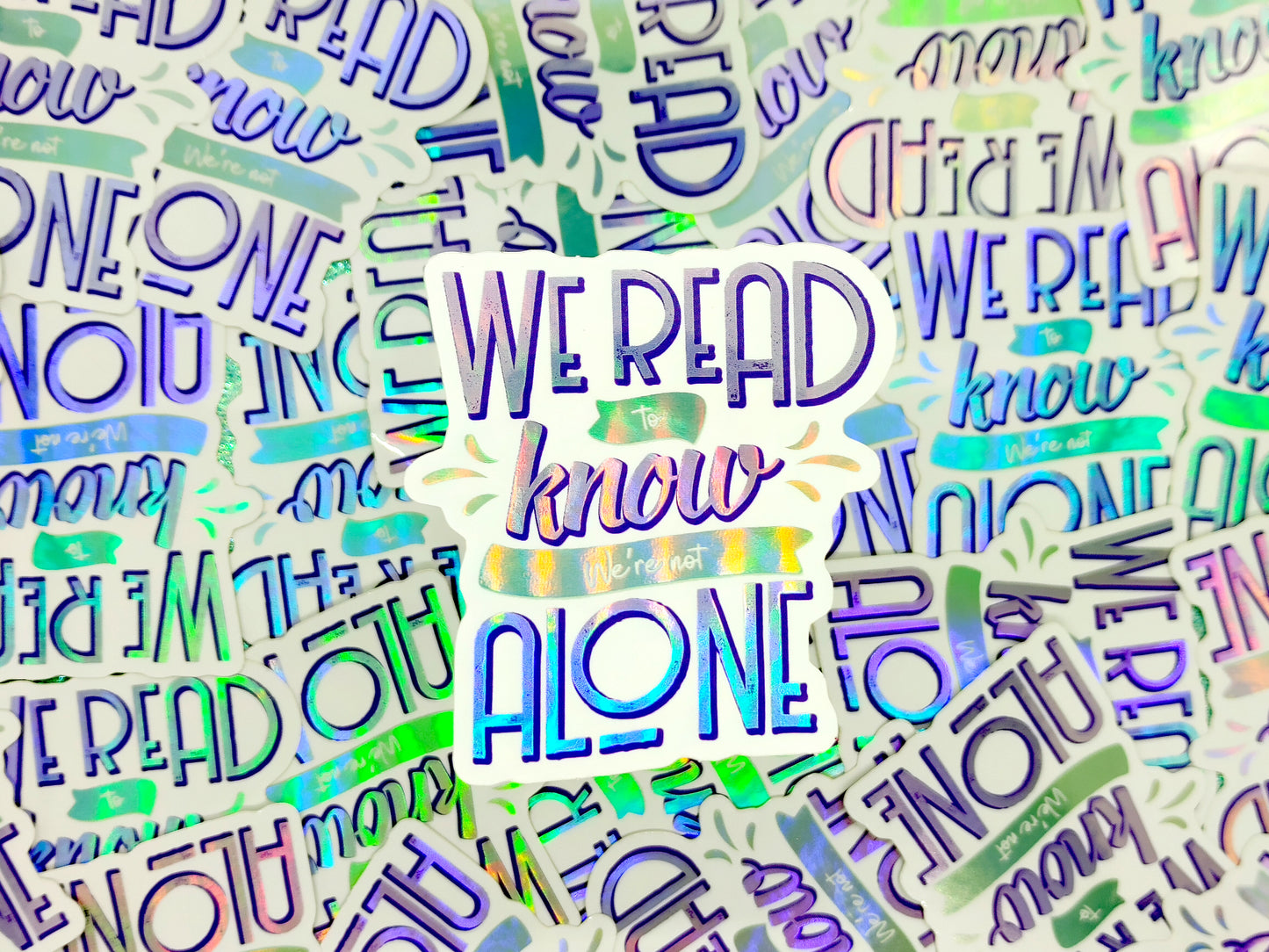 We read to know we're not alone quote holographic bookish vinyl sticker